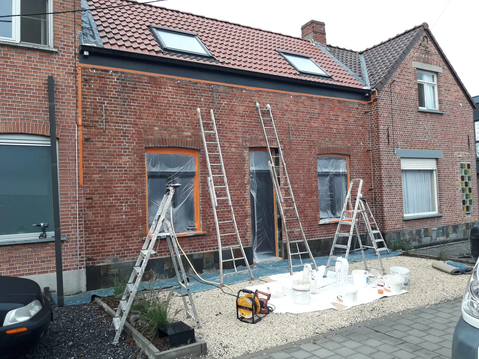 Baksteengevel met vochtvlekken vóór het kaleien